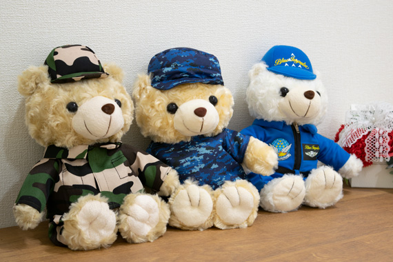 テーブルに座る陸海空作業服姿のベア